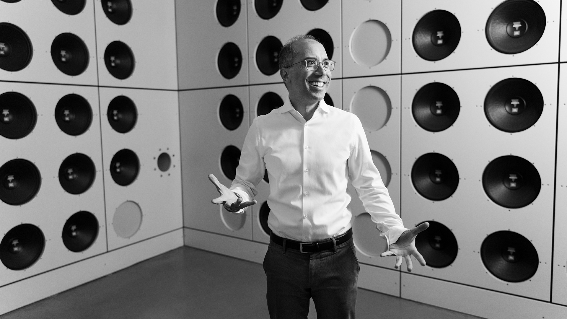 Portrait of Dr. Moni Islam, Head of Development Aerodynamics & Aeroacoustics at Audi, standing in front of the wind tunnel's active silencer. 