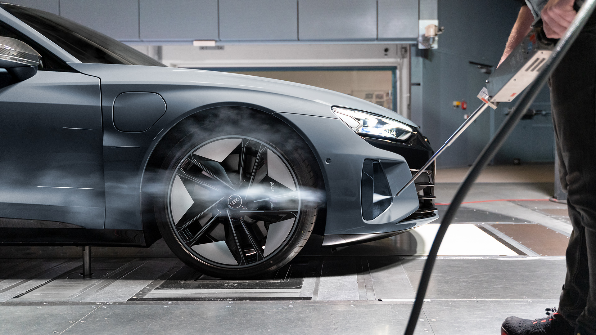 Side profile of the wheel of an Audi RS e-tron GT, a smoke lance demonstrating how the air flows past the wheel arch. 