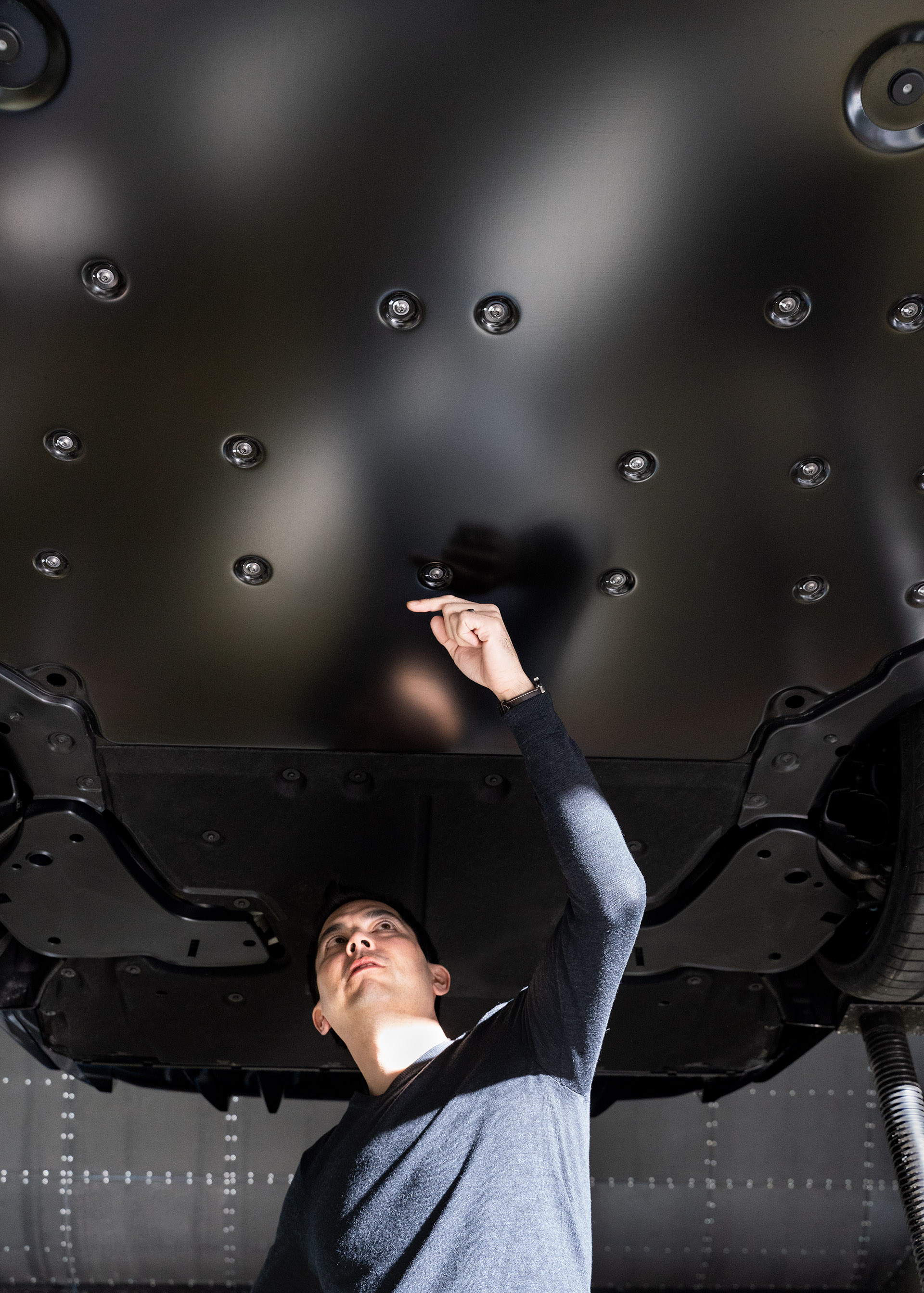 Dr. Kentaro Zens, the aerodynamicist responsible for the Audi RS e-tron GT, standing under the underbody of an RS e-tron GT.