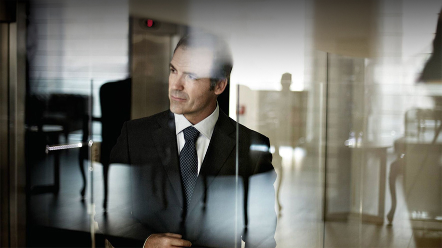 A person looking through a glass door in a corporate office building.