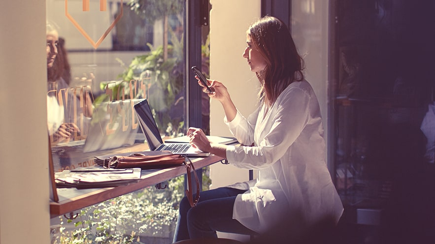 Woman sitting at a laptop in a cafe.