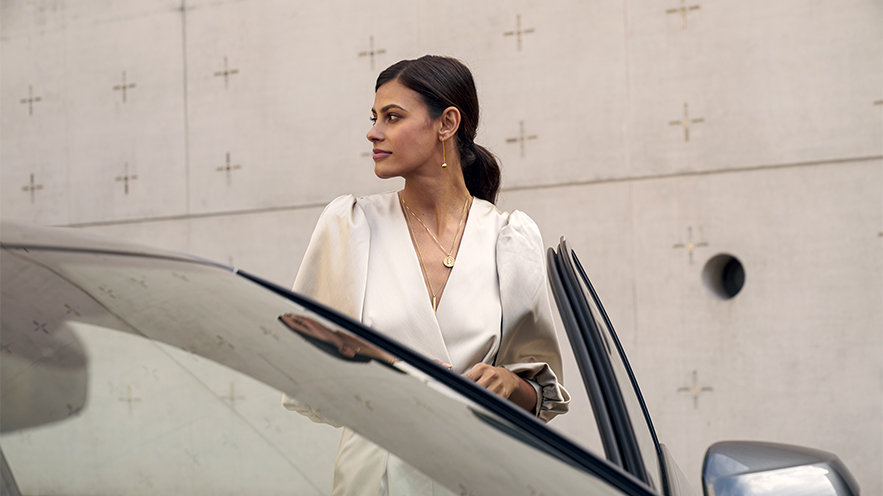 Photo of a well-dressed woman getting into her Audi vehicle.